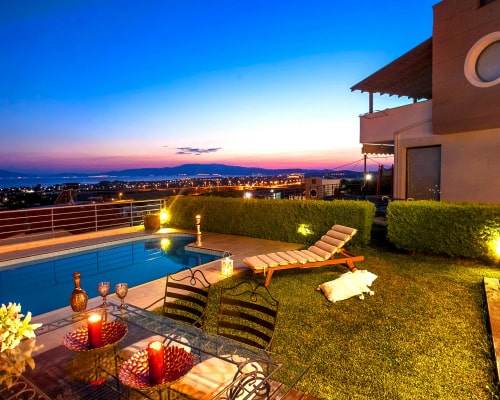 Vacation home patio with pool overlooking town and night sky